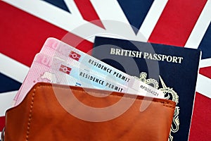 Residence Permit BRP card and British Passport of United Kingdom on Union Jack flag