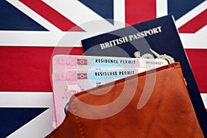 Residence Permit BRP card and British Passport of United Kingdom on Union Jack flag