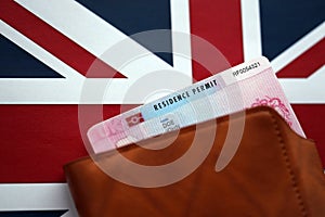 Residence Permit BRP card in purse on Union Jack flag