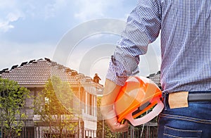 resident engineer holding yellow safety helmet at new home building