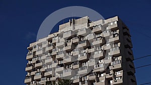 Residential apartment building with balconies on sunny day against blue sky. Urbanistics. Close-up