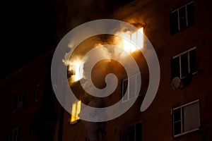 A residential apartment building is on fire at night