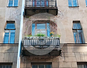 Residential balcony decorated with flowers on facade of the old