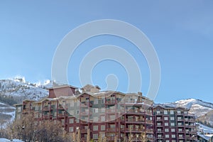 Residential building facade with snowy mountain and blue sky background in winter