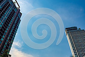 Residential building and office buildings on a cloudy blue sky background