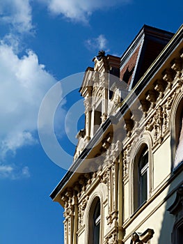 Residential buildings detail with rich stucco decoration and parapet detail under blue sky