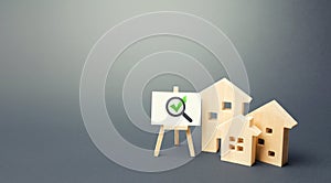 Residential buildings and easel with magnifying glass and green check mark. Compliance of housing with the necessary criteria photo