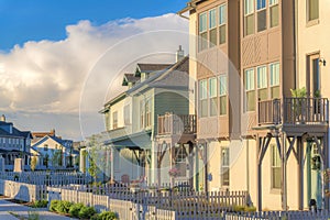 Residential buildings exterior with white picket fence and gate