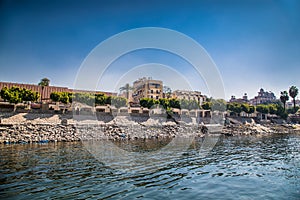 Residential buildings on the Nile river with sailboats in Luxor, Egypt