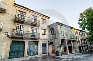 Residential buildings in Pontevedra. Coloured windows masonry walls and stone columns
