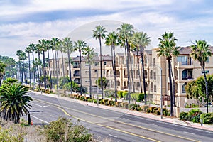 Residential buildings and road lined with palm trees in Huntington Beach CA