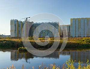 The residential complex under construction is reflected in the water