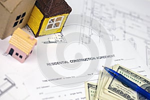 Residential construction agreement ready to sign with small toy houses and pen. Construction contract