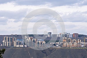 Residential high-rise buildings on top of a mountain across the river.