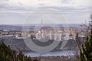 Residential high-rise buildings on top of a mountain across the river.