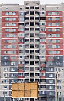 Residential high-rise multi-colored building made of red, gray and white bricks.