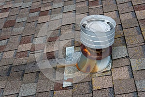 Residential home asphalt shingle rooftop with round roof vent