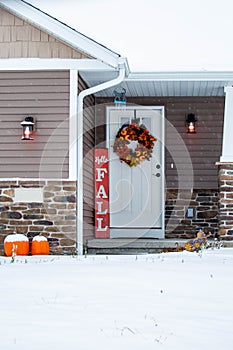 Residential house decorated for autumn with snow on the ground