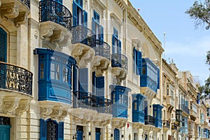 Residential house facade with traditional Maltese navy blue enclosed wooden balconies in Valletta, Malta