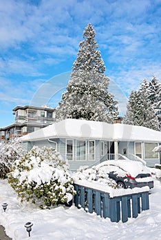 Residential house in snow with a car parked on driveway