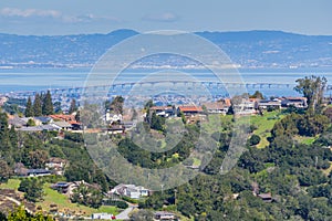 Residential neighborhood on the hills of San Francisco peninsula, Silicon Valley, San Mateo bridge in the background, California photo