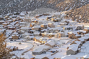 Residential neighborhood with homes and roads on a snowy aerial view in winter