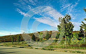 Residential neighborhood with single family houses up on a hill in a sunny day with trees a pathway