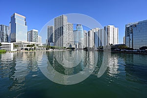 Residential and office towers in downtown Miami Florida reflected in calm water.