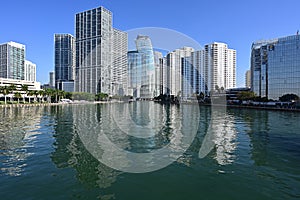 Residential and office towers in downtown Miami Florida reflected in calm water.