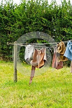 Residential outdoor area with grassy ground and freshly laundered garments hanging from the line