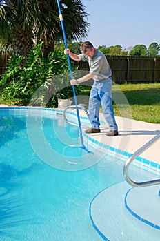 Residential pool cleaning service man working