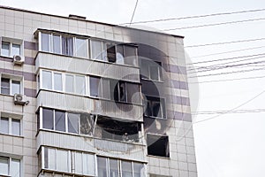 Residential skyscraper after the fire. The smoky facade of the building, black windows, walls and balconies. Burnt