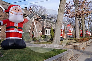 Residential street with a proliferation of giant inflatable Santa Claus dolls