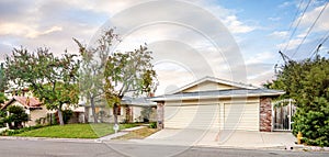 Residential street scene with trees in front of a house in Encino, CA