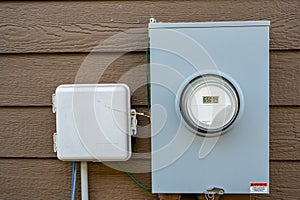 Residential utility electric meter with guage mounted on siding