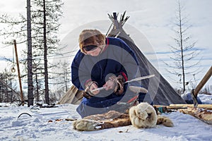 Residents of the far north,  the pasture of Nenets people, the dwelling of the peoples of the north of Yamal, a man makes wooden