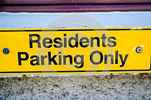 Residents only yellow parking sign on wall