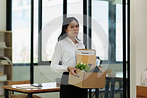 Resignation concept. Fired employee holding box of belongings in an office