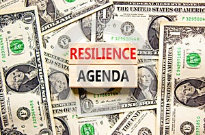 Resilience agenda symbol. Concept word Resilience agenda typed on wooden blocks. Beautiful background from dollar bills. Business