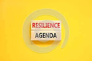 Resilience agenda symbol. Concept word Resilience agenda typed on wooden blocks. Beautiful yellow table yellow background.