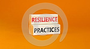 Resilience practices symbol. Concept word Resilience practices typed wooden blocks. Beautiful orange table orange background.