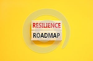 Resilience roadmap symbol. Concept word Resilience roadmap typed on wooden blocks. Beautiful yellow table yellow background.