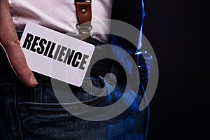 resilience word inscription on white card paper sheet in hands of a businessman. recap concept