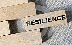 RESILIENCE - word on a wooden bar on a gray background