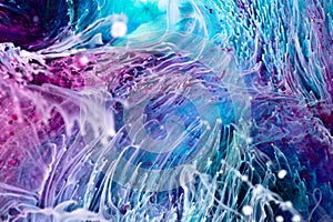 Resin art paint with blue, purple and white colors. Liquid background with splashes and ripples. Modern abstract texture