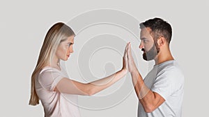 Resist domestic tyrant. Concentrated woman pushes male hands with hands, staring at each other menacingly