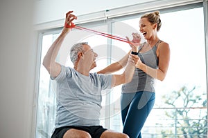 Resistance is most definitely not futile. an attractive mature woman helping her husband with his workout at home.