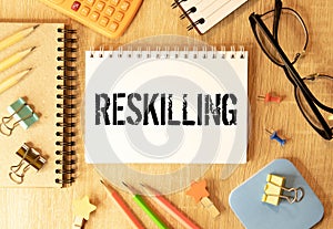 Reskilling text on sticky notes with office desk.