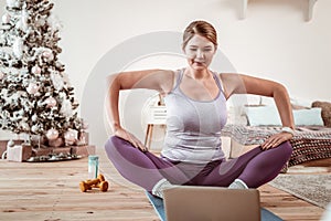 Resolute appealing woman recreating yoga posture from video lesson