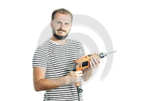 A resolute bearded man holds a power tool - electric drill in his hands. Isolated on white background